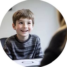A smiling boy talking with a clinician