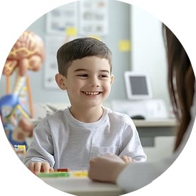 A smiling boy at a table during an assessment